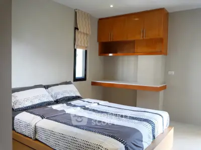 Modern bedroom with stylish wooden cabinetry and cozy bedding