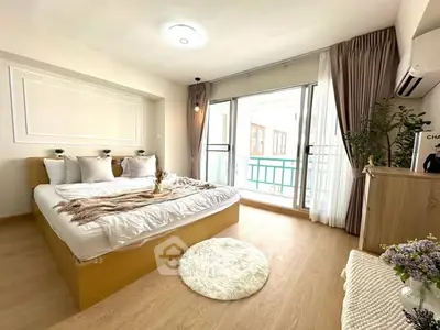 Bright and cozy bedroom with modern decor and large windows for natural light.