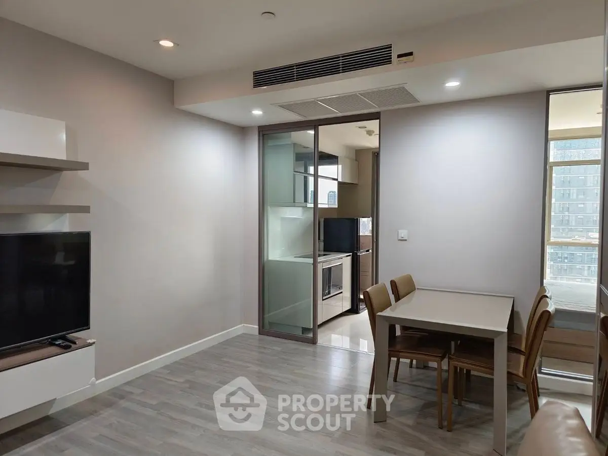 Modern apartment interior with open layout, featuring sleek kitchen and dining area.