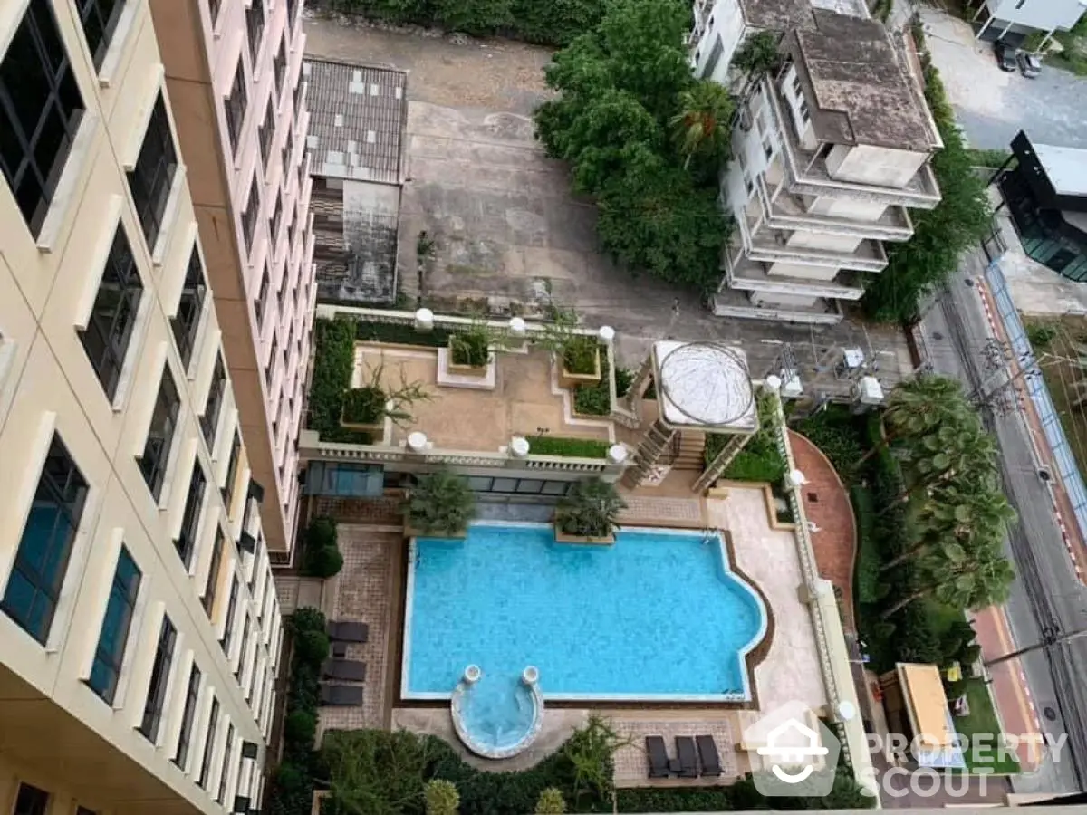 Stunning aerial view of luxurious apartment complex with inviting swimming pool and lush greenery.