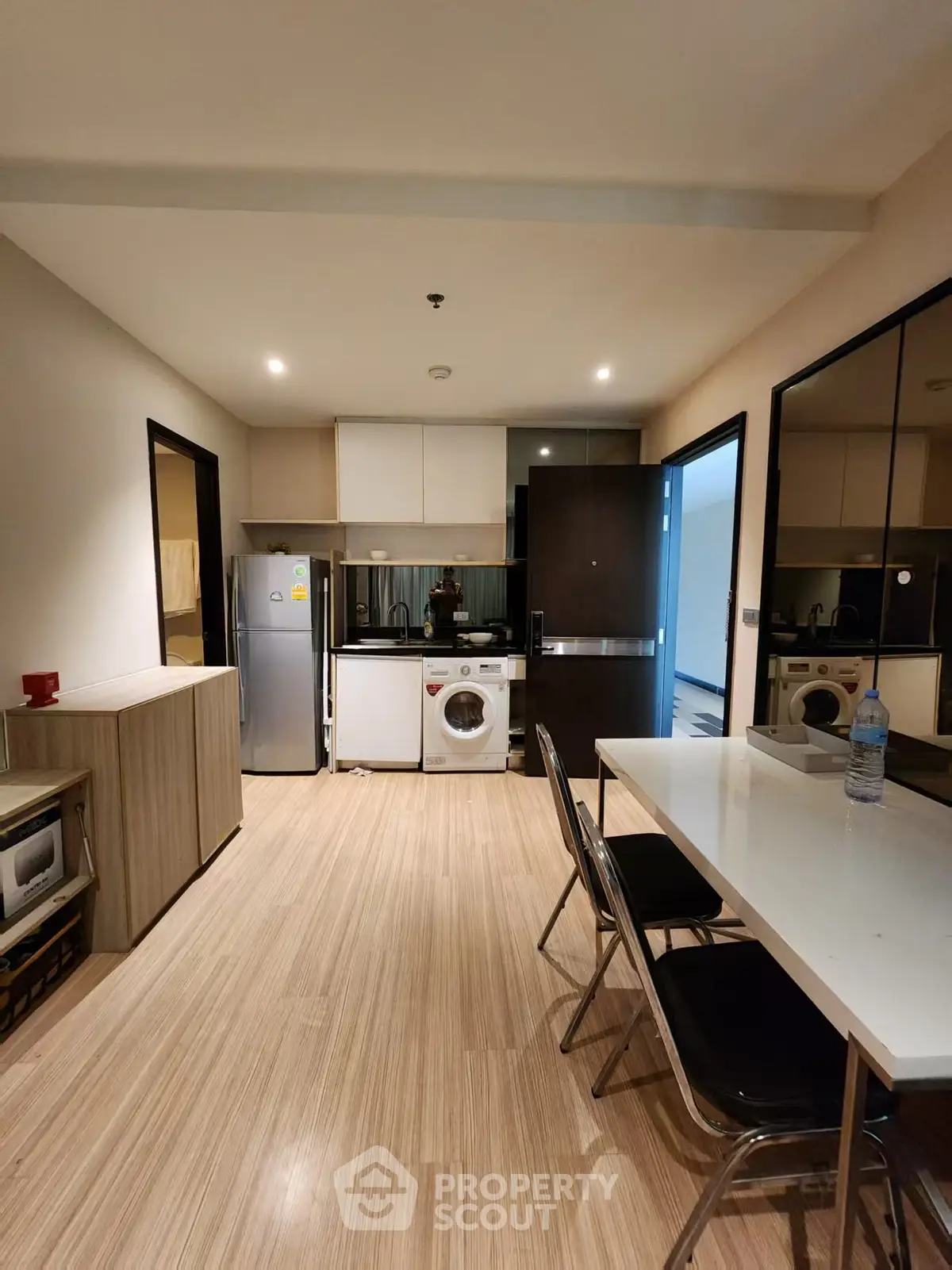 Modern kitchen with washing machine and dining area in sleek apartment