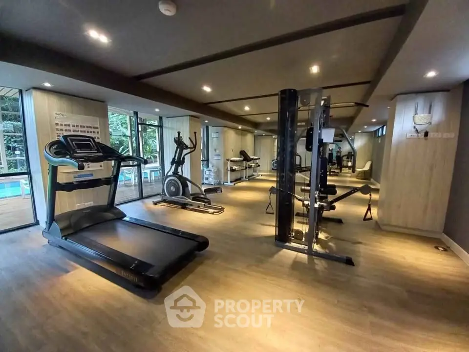 Modern gym with state-of-the-art equipment and pool view, perfect for fitness enthusiasts.
