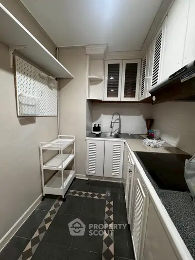 Compact kitchen with modern cabinetry and sleek countertops in a cozy apartment.