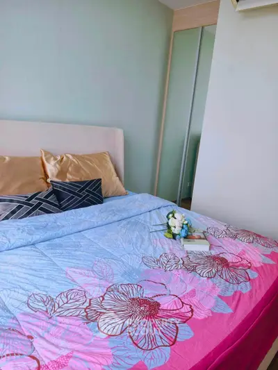 Cozy bedroom with floral bedding and mirrored wardrobe in modern apartment.