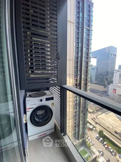 Modern high-rise apartment balcony with washing machine and city view