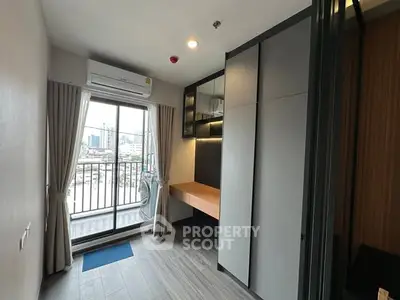 Modern bedroom with balcony view and built-in storage in urban apartment.