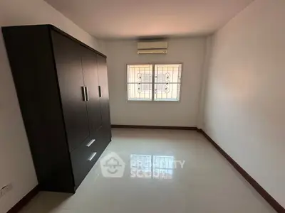 Spacious bedroom with large wardrobe and air conditioning unit