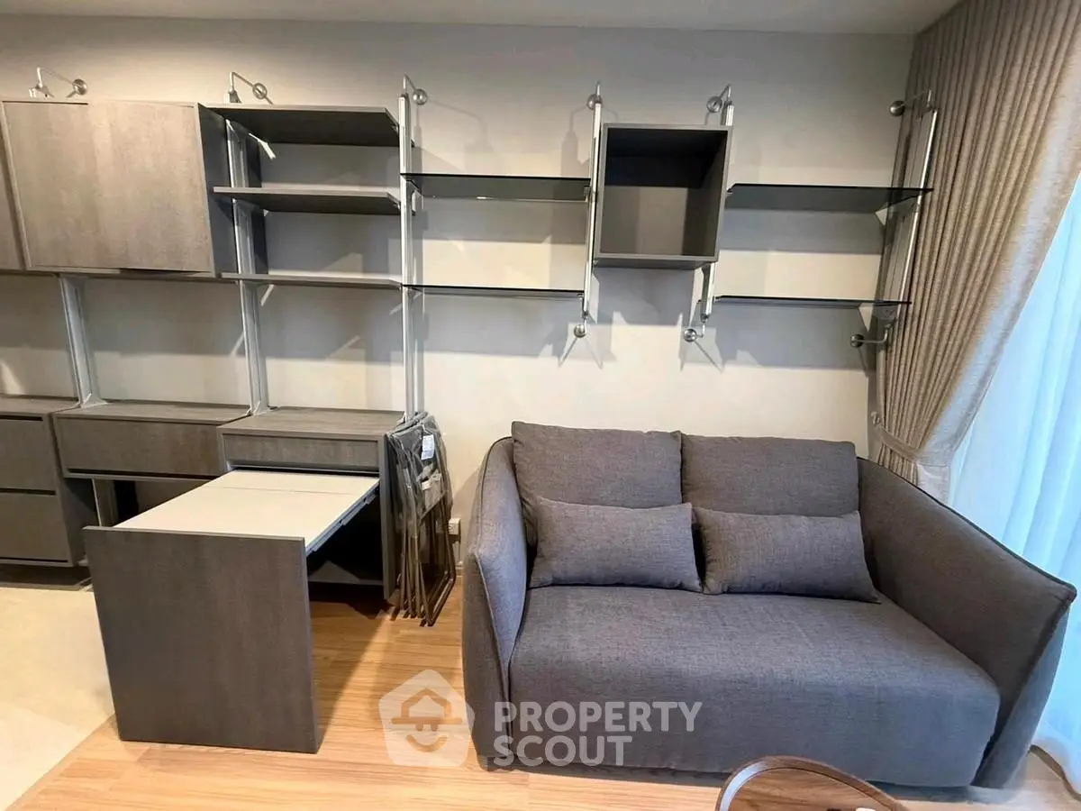 Modern living room with stylish grey sofa and wall-mounted shelving unit