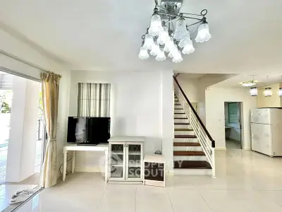 Spacious living room with modern decor and elegant staircase in a bright, airy home.