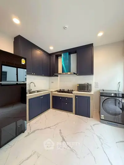 Modern kitchen with sleek appliances and stylish cabinetry in a contemporary home.