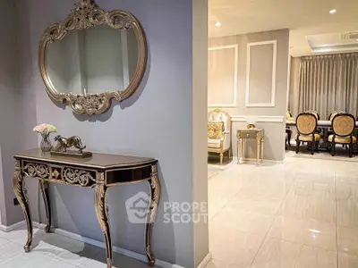 Luxurious living room with elegant furniture and ornate mirror, showcasing sophisticated interior design.