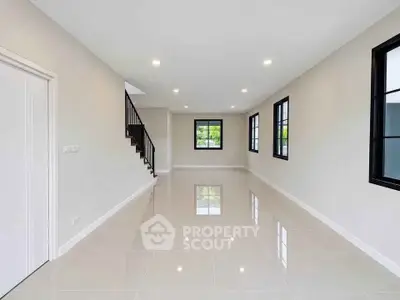 Spacious modern living room with glossy tiled floors and large windows