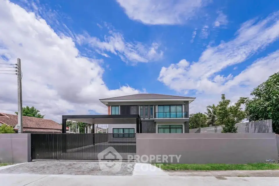 Modern two-story house with sleek design and spacious driveway under a vibrant blue sky.
