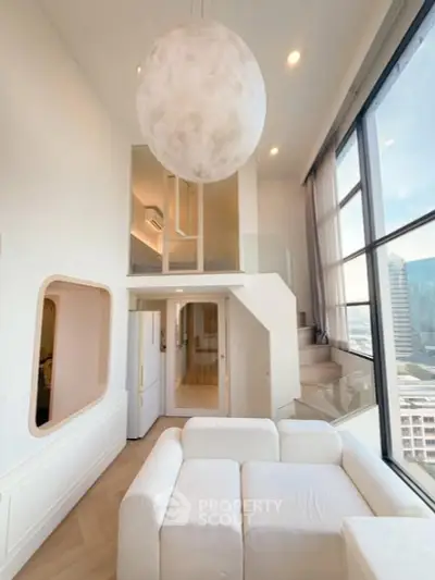 Stunning modern loft with high ceilings and large windows offering city views, featuring a unique spherical light fixture.