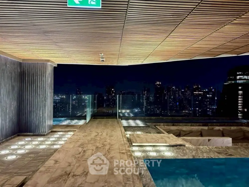 Luxurious rooftop pool with stunning city skyline view at night.