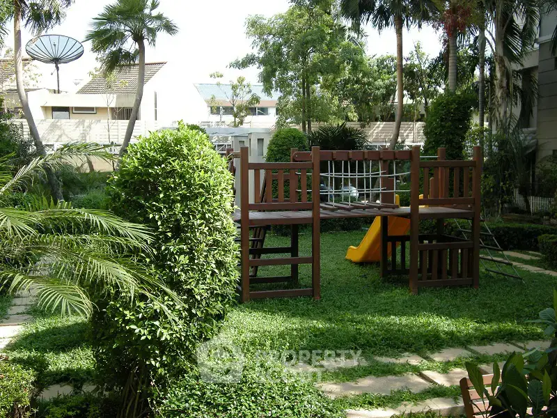 Lush garden with playground in a residential complex, perfect for family living.
