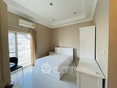 Bright and airy bedroom with modern furnishings and balcony view.