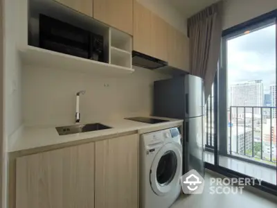 Modern kitchen with washing machine and balcony view in urban apartment