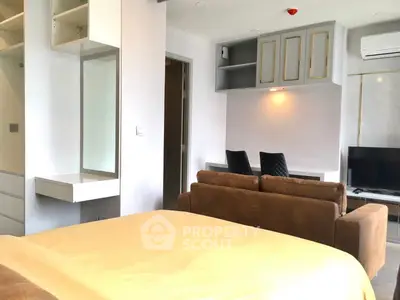 Modern studio apartment with cozy living area and built-in storage solutions.