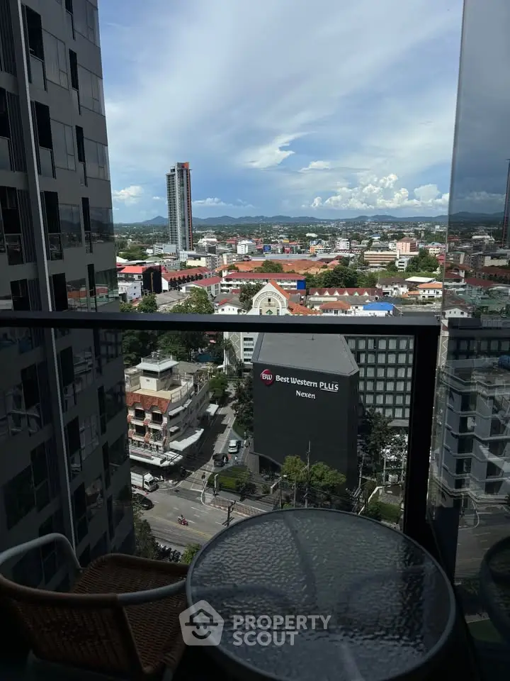Stunning cityscape view from a high-rise balcony with modern glass railing.