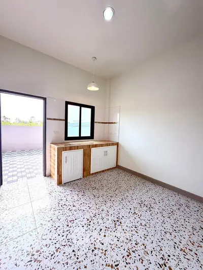 Spacious kitchen with terrazzo flooring and outdoor access, perfect for modern living.