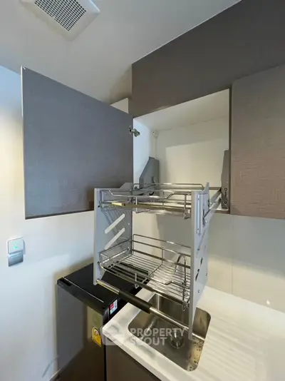 Modern kitchen with sleek cabinetry and innovative pull-down storage rack.