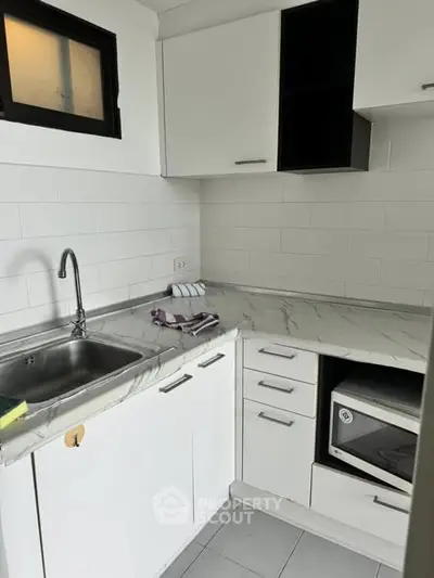 Modern kitchen with sleek white cabinetry and marble countertops
