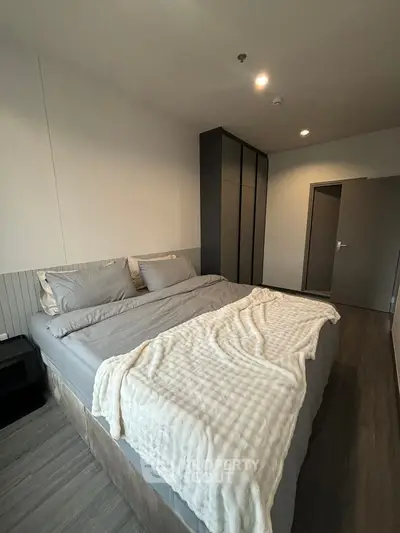 Spacious modern bedroom with cozy bedding and sleek wardrobe