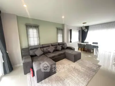 Spacious modern living room with stylish gray sectional sofa and dining area