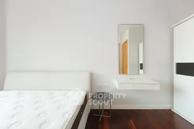 Modern minimalist bedroom with sleek furniture and hardwood floors