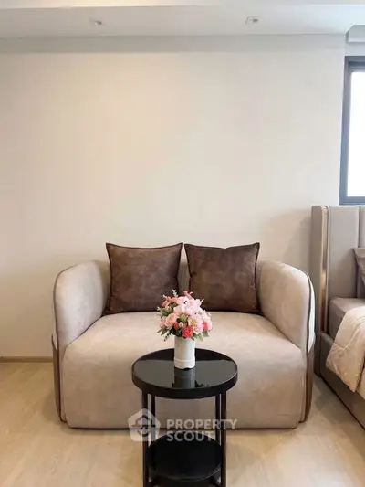 Cozy living room with elegant beige sofa and floral centerpiece, perfect for relaxation and style.