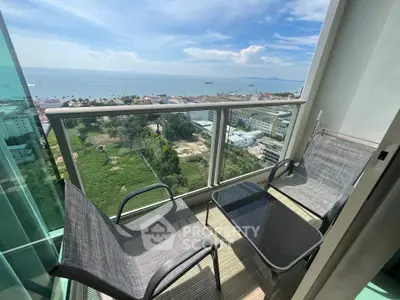 Stunning balcony view with ocean and cityscape, featuring modern outdoor seating.