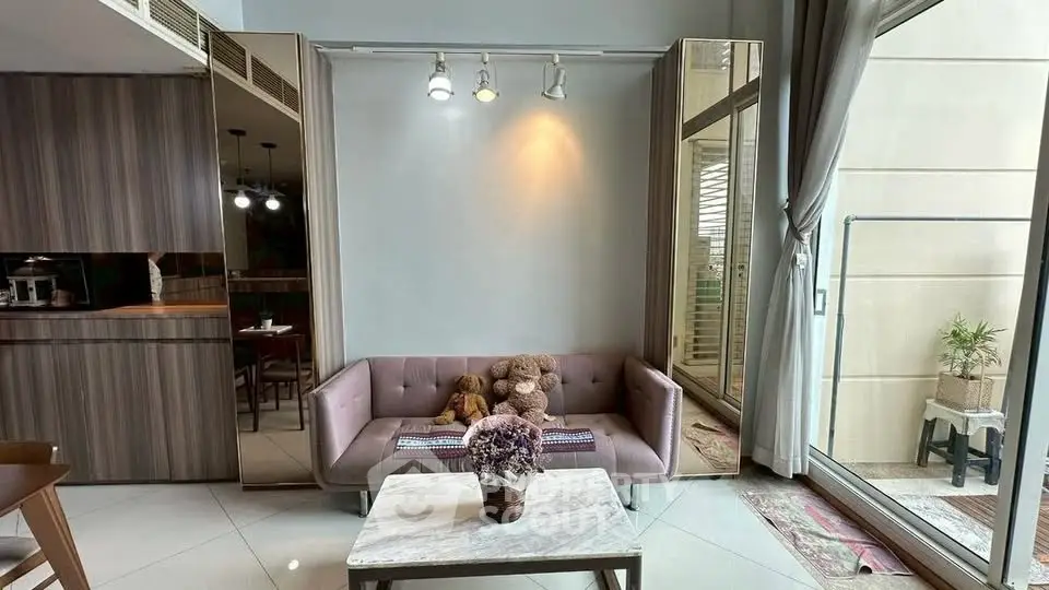 Stylish living room with modern decor and large windows opening to a balcony, perfect for urban living.