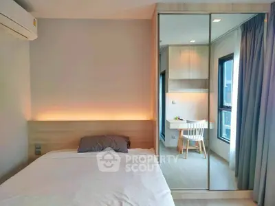 Modern bedroom with mirrored wardrobe and cozy workspace by the window, perfect for urban living.