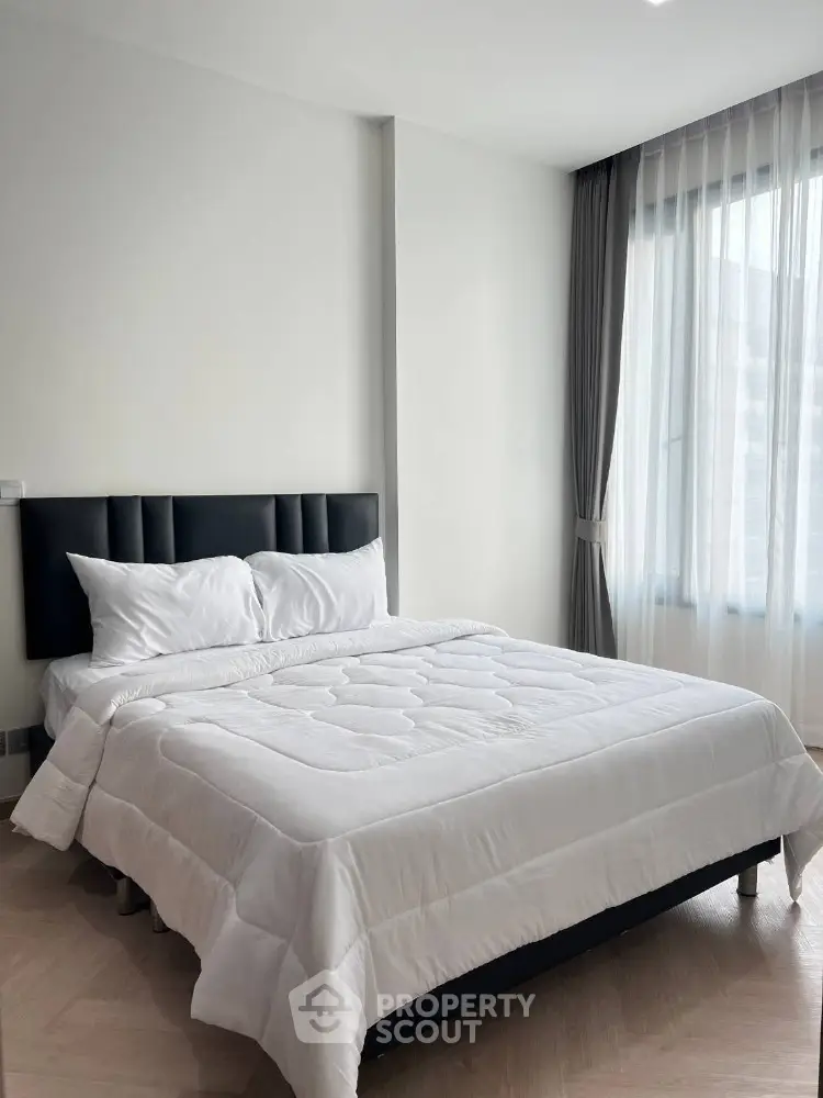 Modern bedroom with elegant decor and large window for natural light