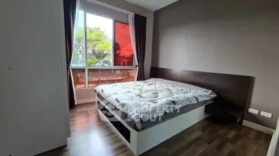 Cozy bedroom with large window and modern decor, featuring a comfortable bed and stylish flooring.