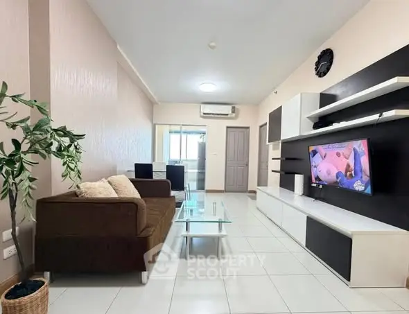 Modern living room with sleek furniture and wall-mounted TV, perfect for relaxation and entertainment.