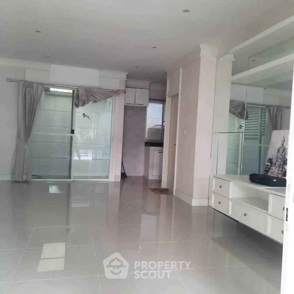 Spacious living room with glossy tiled floors and large windows for natural light.