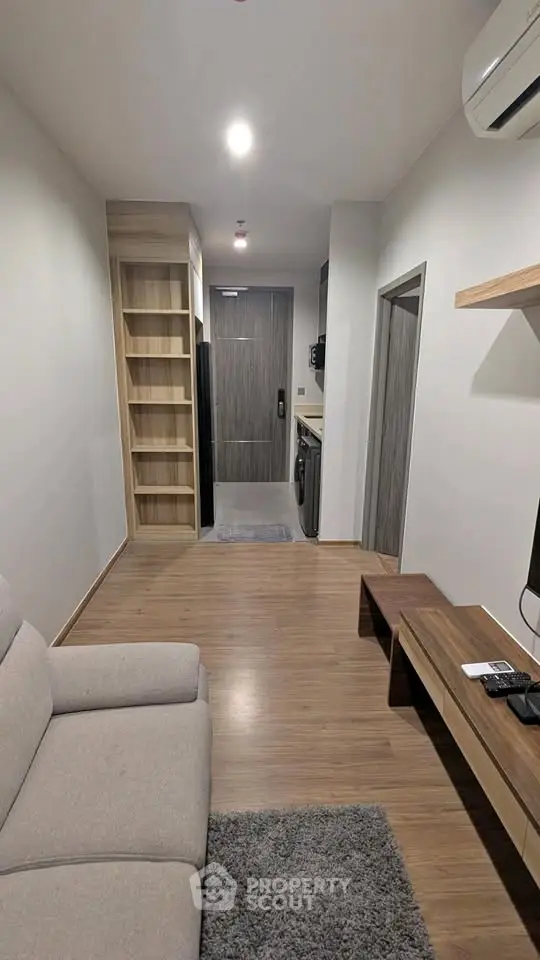 Modern apartment interior with cozy living area and sleek kitchen appliances.