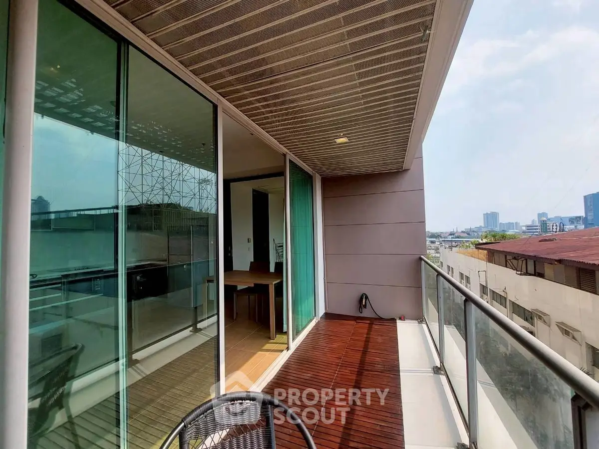Spacious balcony with modern glass railing and city view, perfect for relaxation and entertainment.