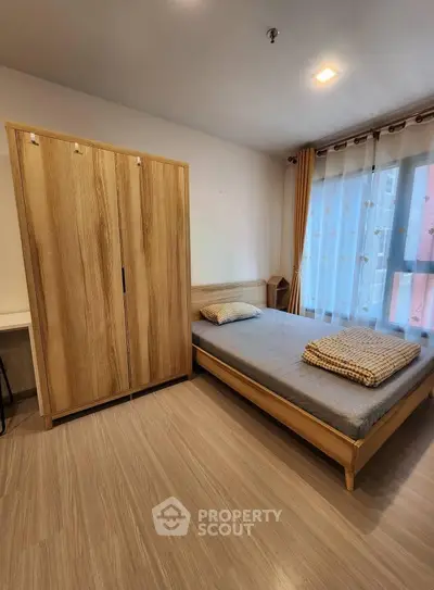 Modern bedroom with wooden furniture and large window for natural light