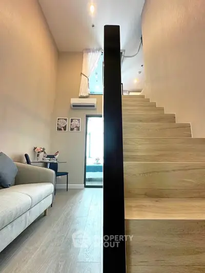 Modern duplex interior with wooden staircase and cozy living area