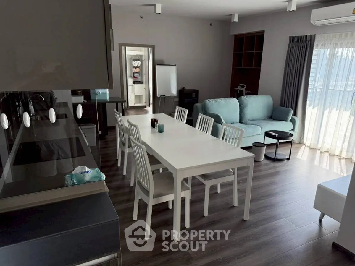 Spacious modern living room with elegant dining area and natural light.