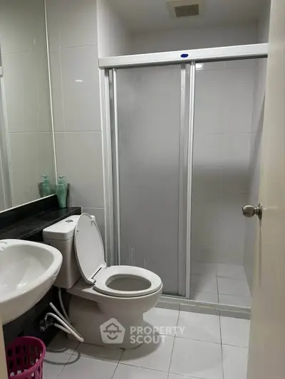 Modern bathroom with sleek shower and contemporary fixtures in a stylish apartment.