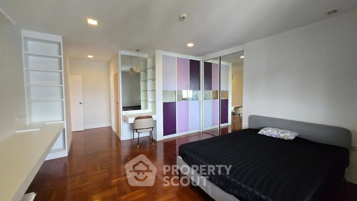 Spacious modern bedroom with sleek design and mirrored wardrobe