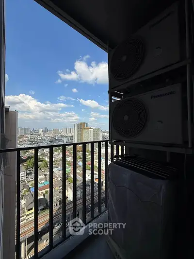 Stunning city view from a high-rise balcony with air conditioning units, showcasing urban skyline and blue skies.
