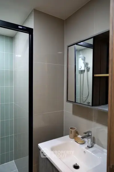 Modern bathroom with sleek shower and stylish sink in contemporary apartment.