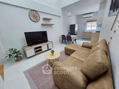 Spacious living room with modern decor and open kitchen layout, perfect for family gatherings.