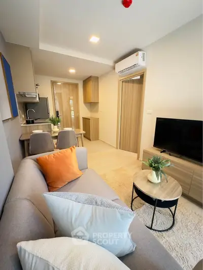 Modern living room with cozy sofa, dining area, and stylish kitchen in open layout apartment.