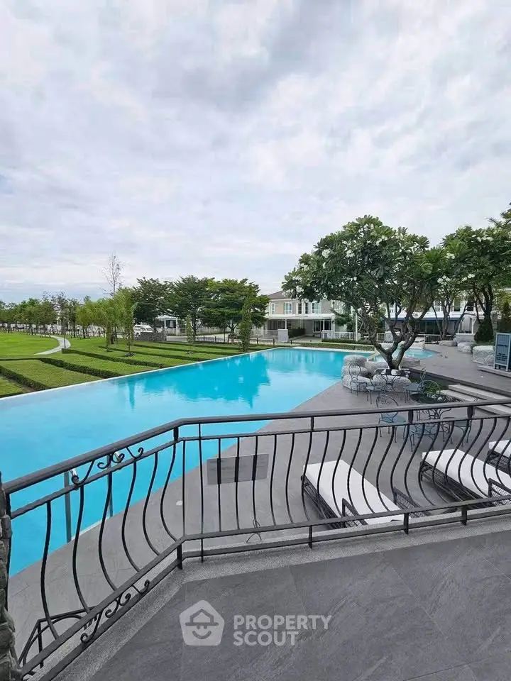 Luxurious residential pool area with elegant railing and lush greenery